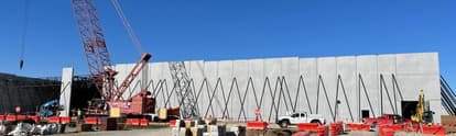 a construction site with a precast concrete panel being installed.